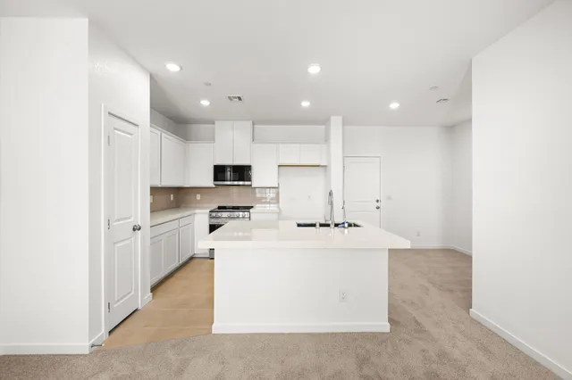 A kitchen with white cabinets.