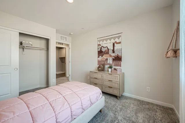 A bedroom with a pink bed.