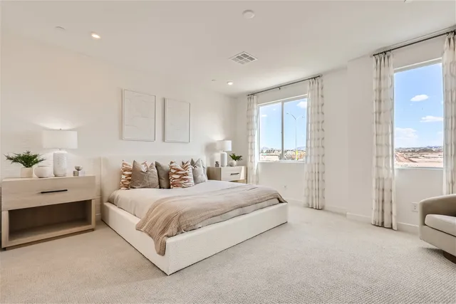 A bedroom with a large window.