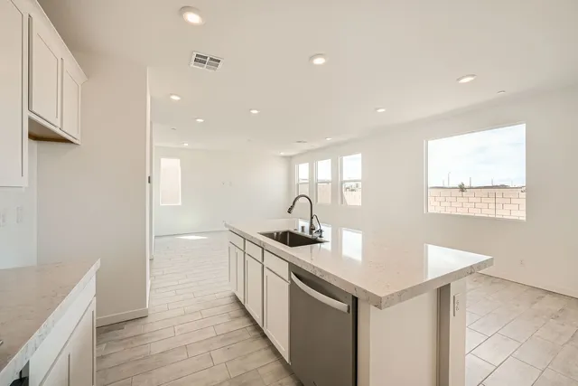 A kitchen with white cabinets.